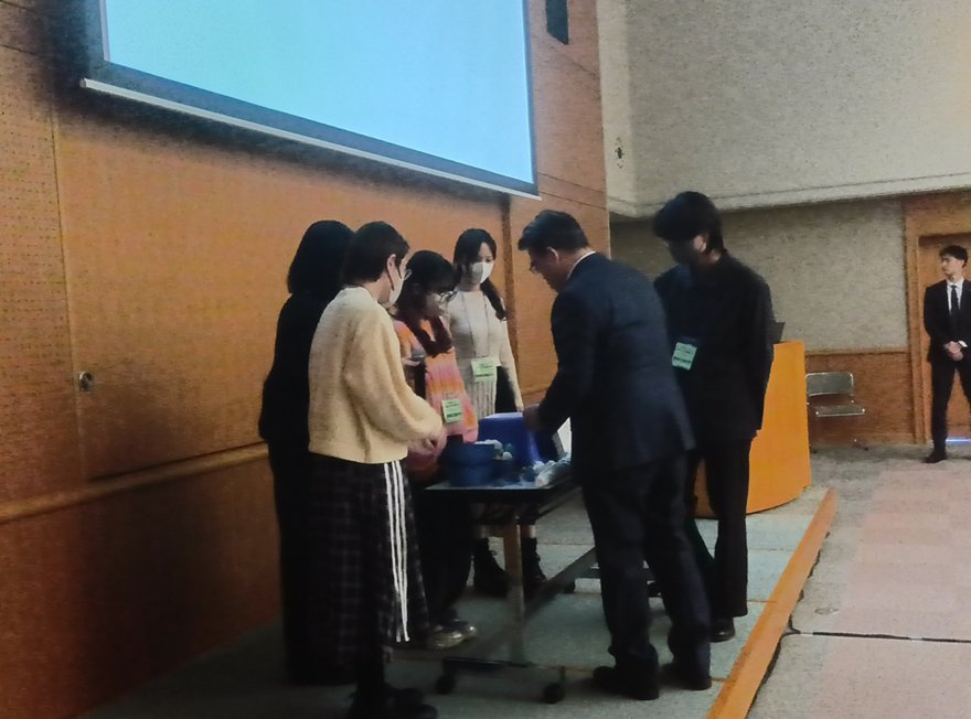 知事に開発したアイテムを紹介する本学学生